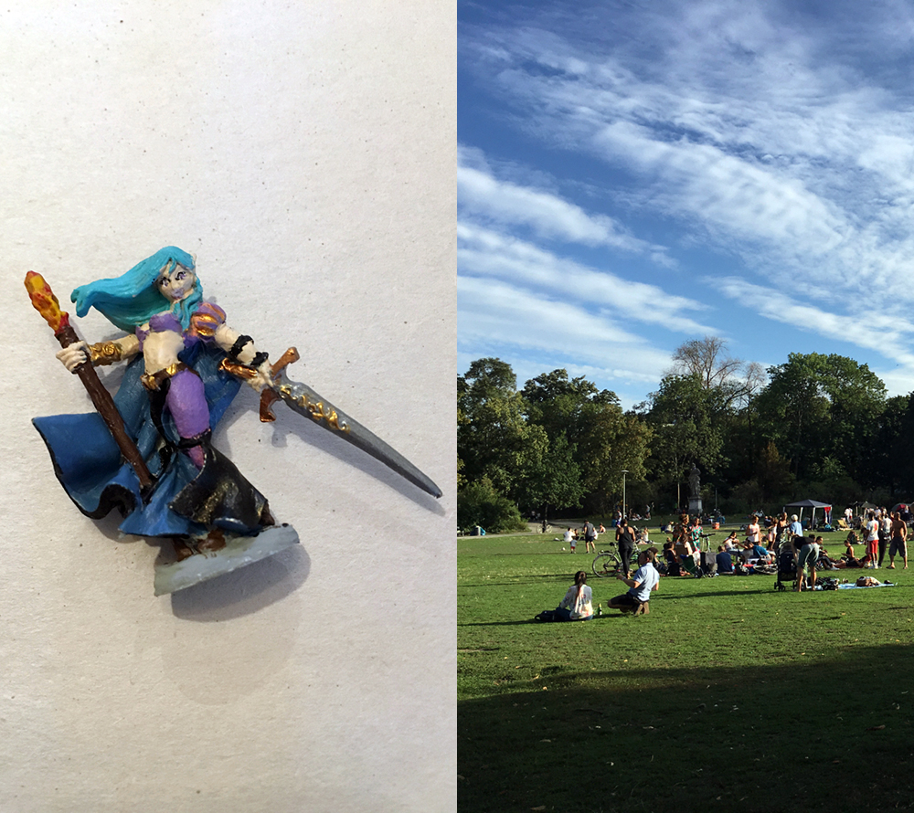 My painted D&D figurine, a warrior with a sword and floating teal hair; people sitting in the grass on a beautiful day at Thai Park.