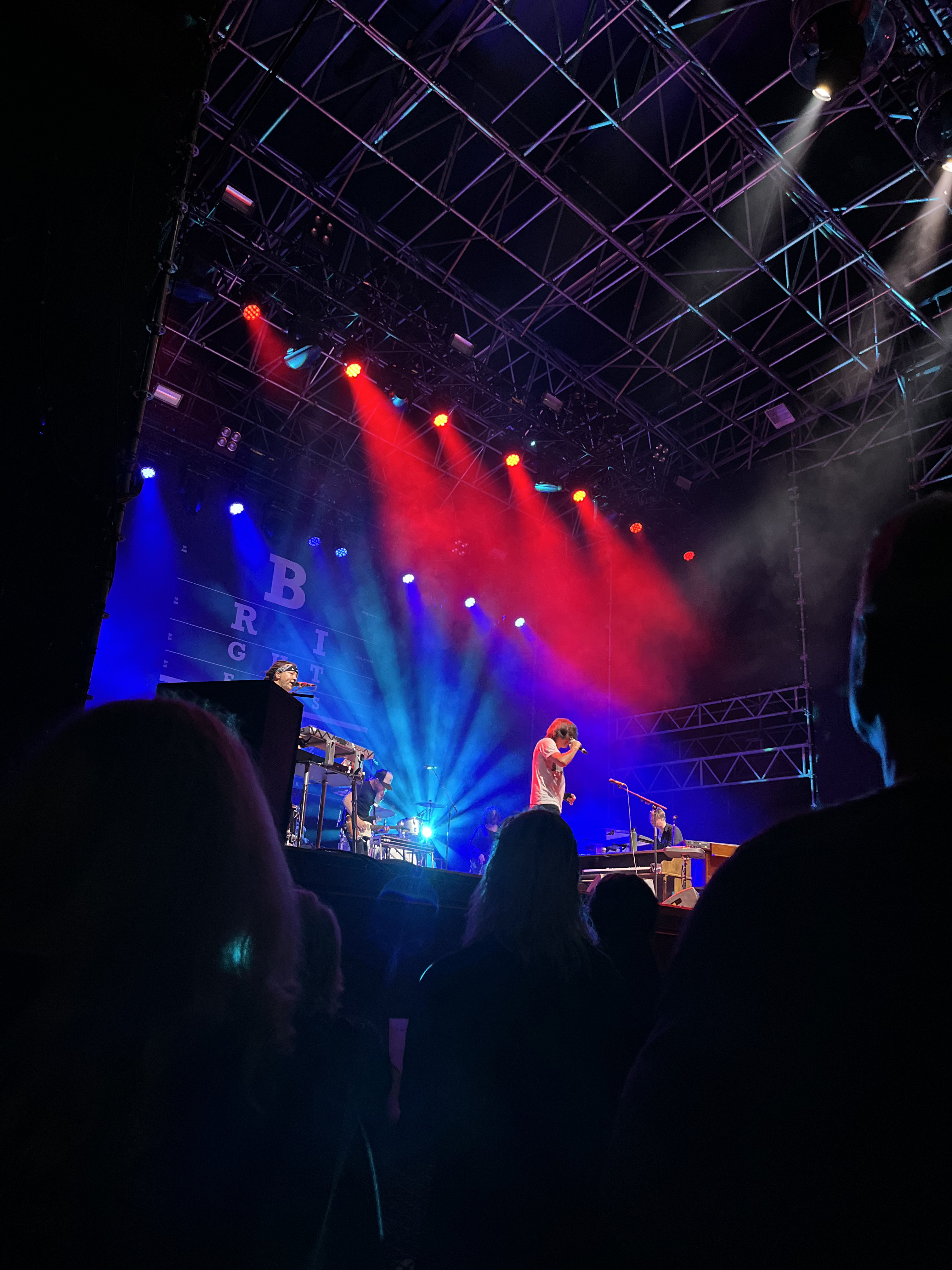 the band Bright Eyes on an outdoor stage at night-time, photographed from the crowd