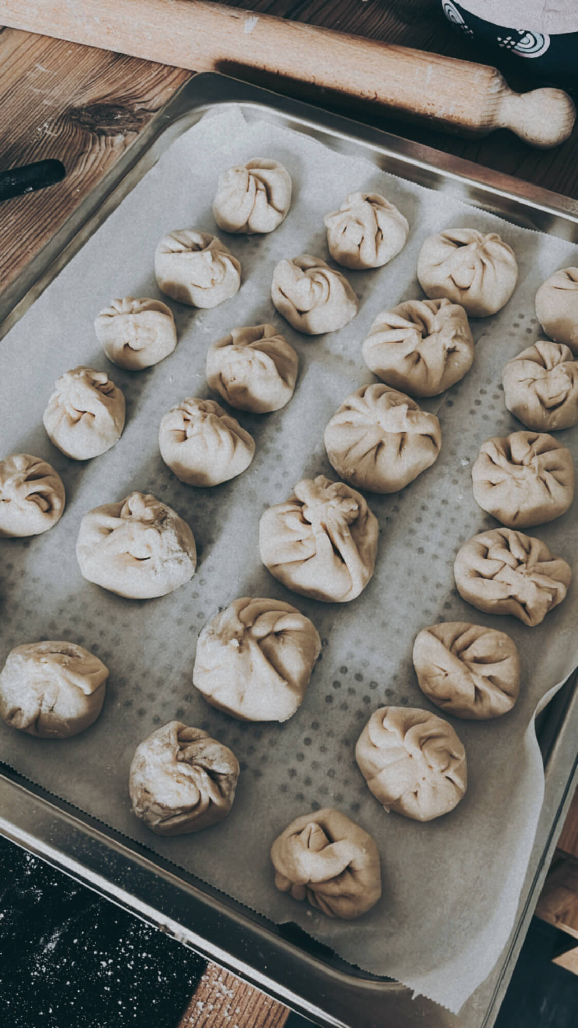 Uncooked dumplings in an oven steam rack, on a kitchen countertop